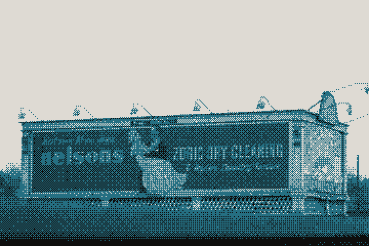 A lit advertising billboard beside a city bridge, 1932