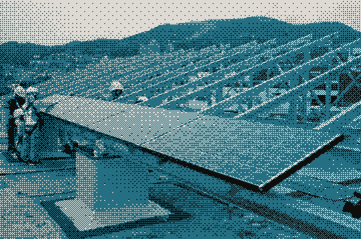 Installers fitting solar panels onto a rooftop frame
